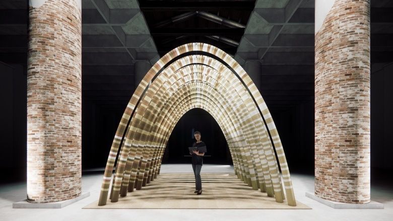 Arched woven installation inside the brick-columned Corderie interior