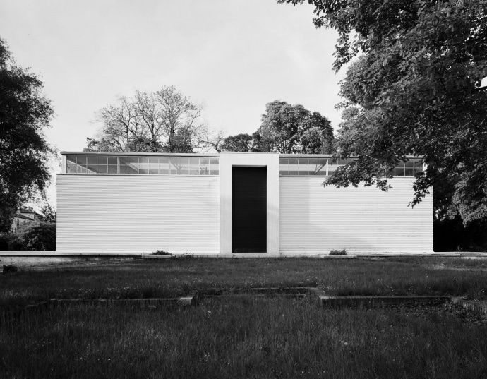 Black-and-white view of a modernist pavilion with a central dark entrance