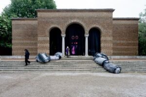 Contemporary sculptures flank the entrance to a brick exhibition building